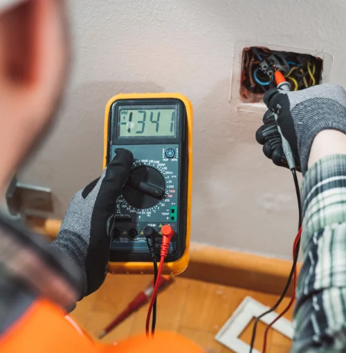 Electrician testing a socket with a multifunction tester